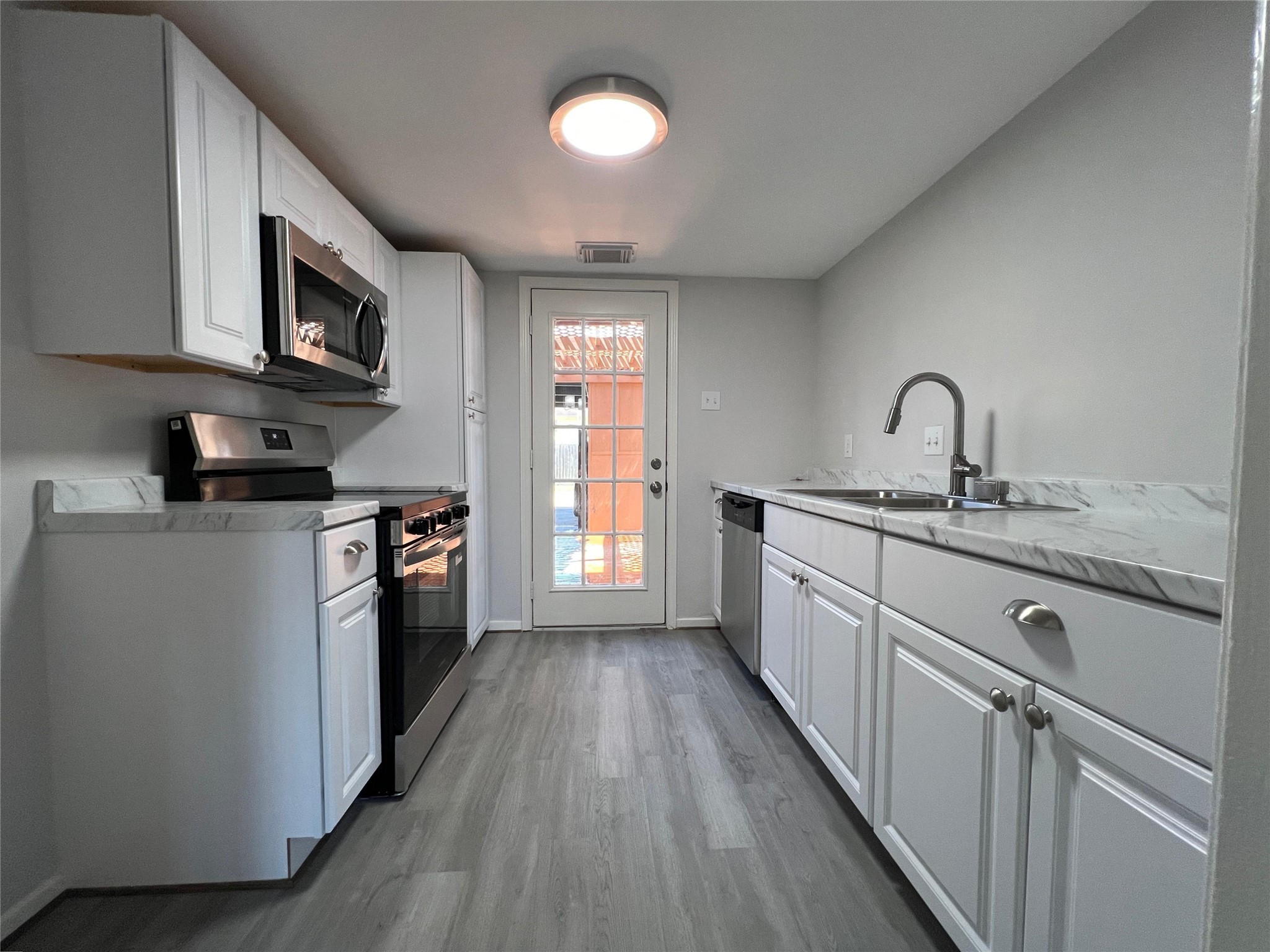 7012 Jetty Lane Houston, TX 77072 - Photo 6 of 24 a kitchen with stainless steel appliances granite countertop a sink cabinets and wooden floor