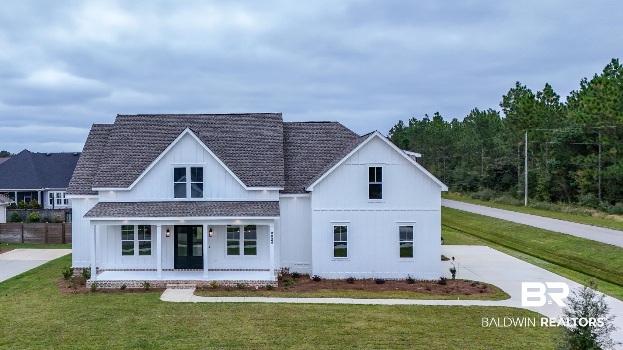 10985 Atrium Avenue Fairhope, AL 36532 - Photo 1 of 58 Modern farmhouse style home with a front lawn, a porch, a shingled roof, and board and batten siding