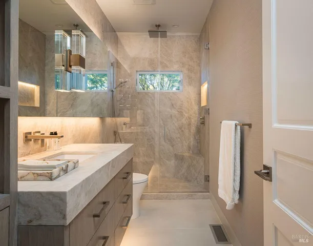 a bathroom with double vanity sinks a large mirror and a shower