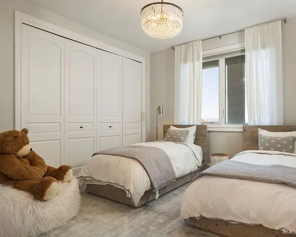 a bedroom with a bed and a chandelier