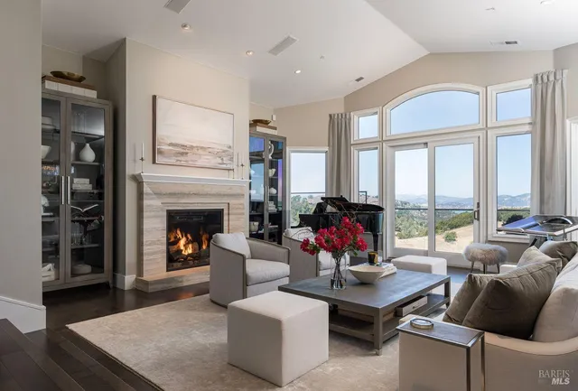 a living room with furniture fireplace and a large window