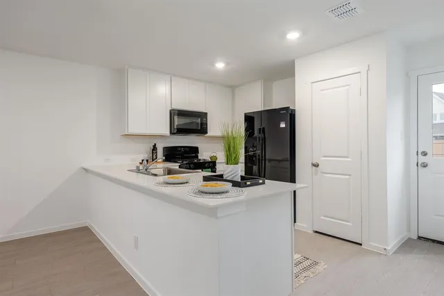 a kitchen with a refrigerator a stove a microwave and a counter top space