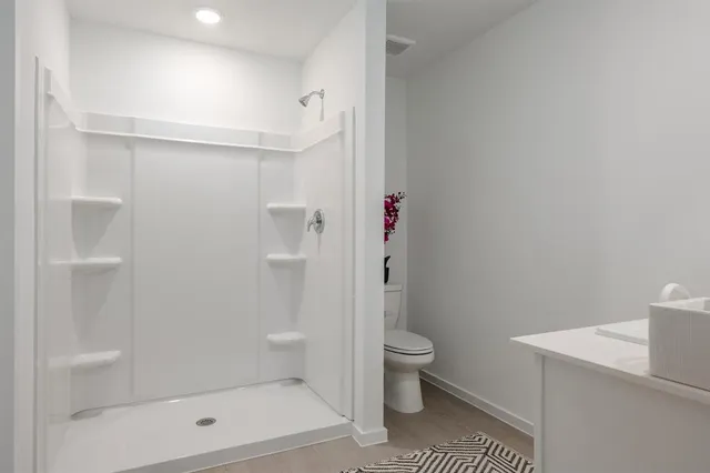 a bathroom with a shower a toilet and a shower