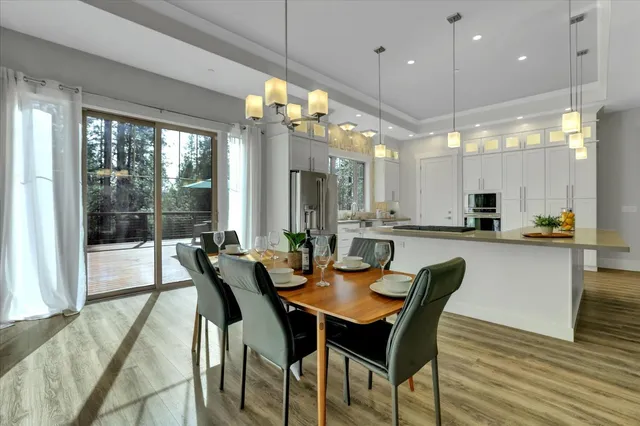 a dining room with furniture a chandelier and wooden floor