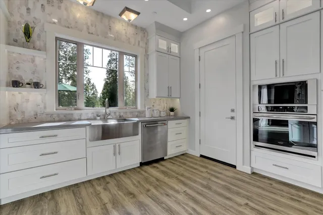 a kitchen with granite countertop a stove a sink and a refrigerator