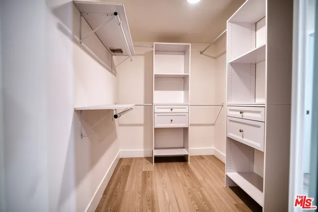 a view of walk in closet with empty racks