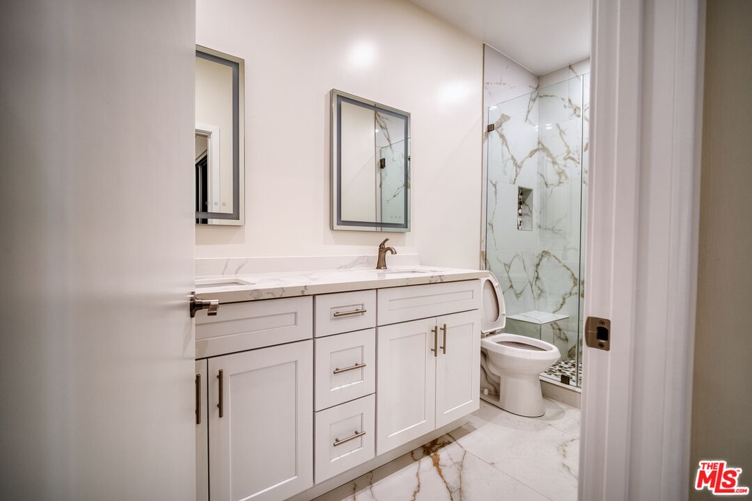 13920 Moorpark Street, Unit 201 Sherman Oaks, CA 91423 - Photo 12 of 25 a spacious bathroom with a toilet sink and mirror