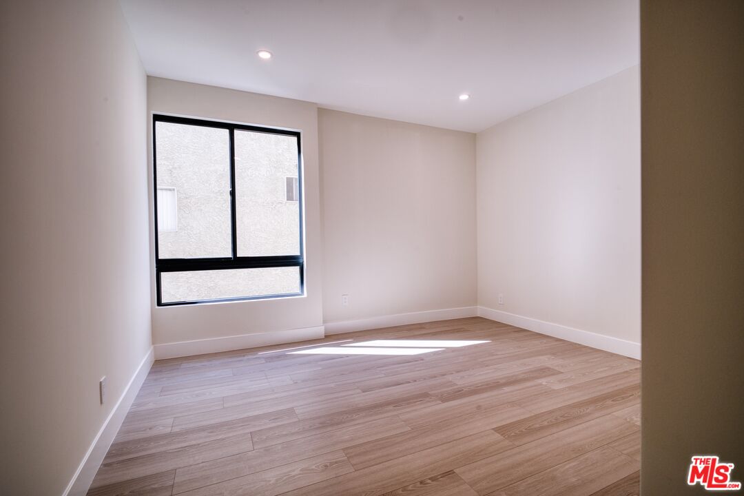 13920 Moorpark Street, Unit 201 Sherman Oaks, CA 91423 - Photo 15 of 25 an empty room with wooden floor and windows