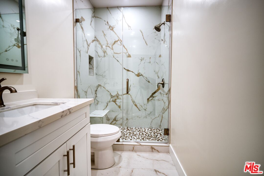 13920 Moorpark Street, Unit 201 Sherman Oaks, CA 91423 - Photo 18 of 25 a bathroom with a granite countertop sink toilet and shower