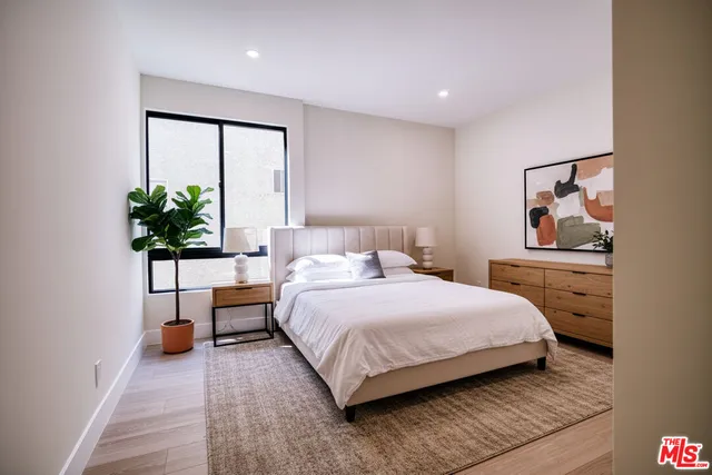 a bedroom with a bed and a potted plant