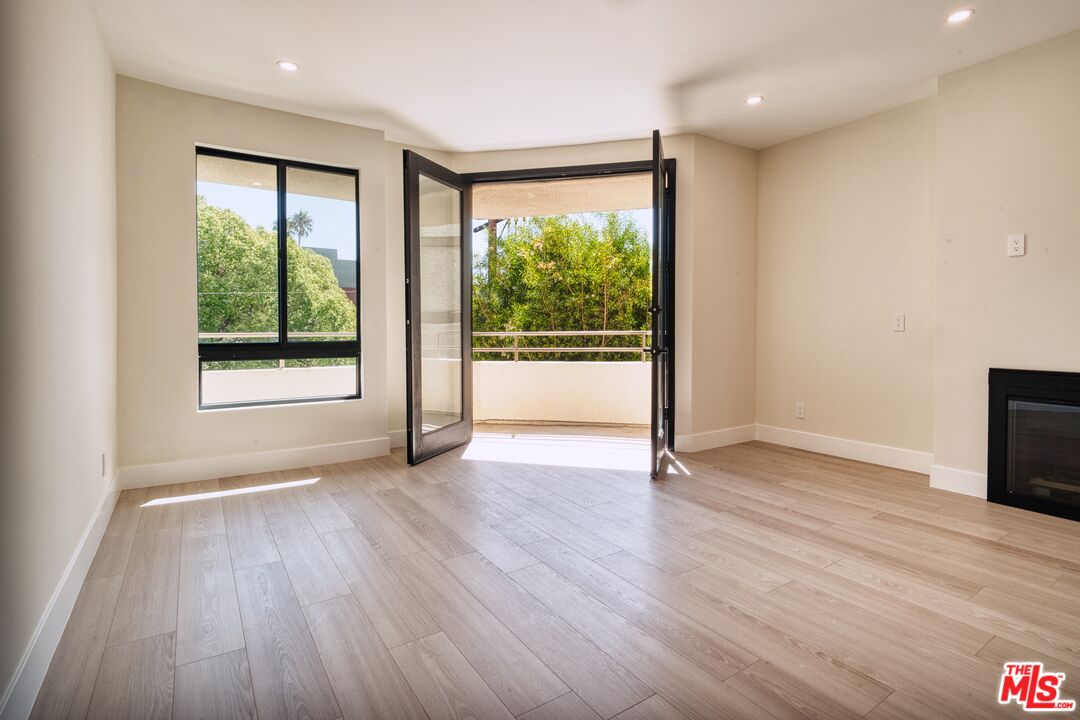 13920 Moorpark Street, Unit 201 Sherman Oaks, CA 91423 - Photo 4 of 25 an empty room with wooden floor and windows