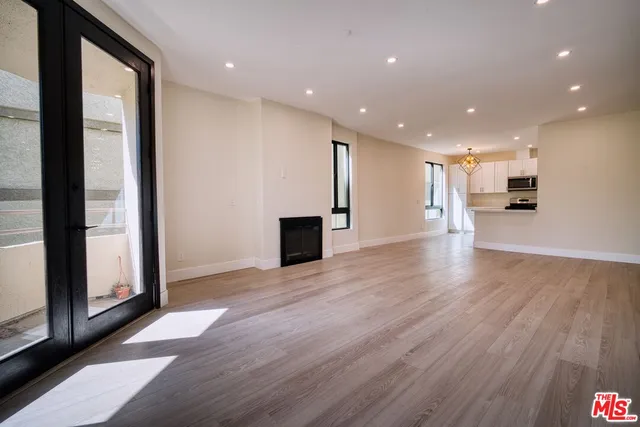 a view of a big room with wooden floor and windows