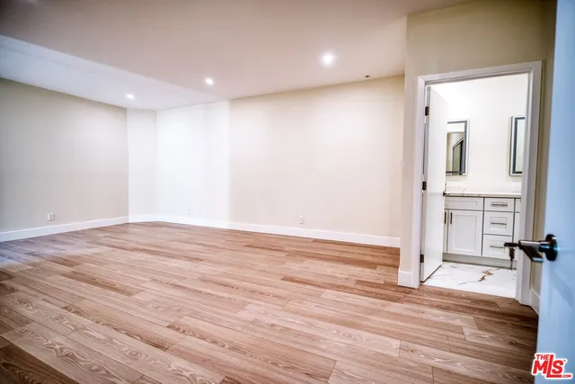 a view of empty room with wooden floor and fireplace