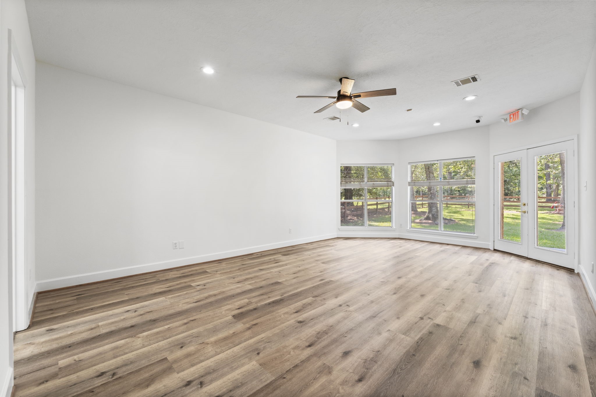 15456 Pin Oak Drive Conroe, TX 77384 - Photo 22 of 44 a view of an empty room with a window and wooden floor
