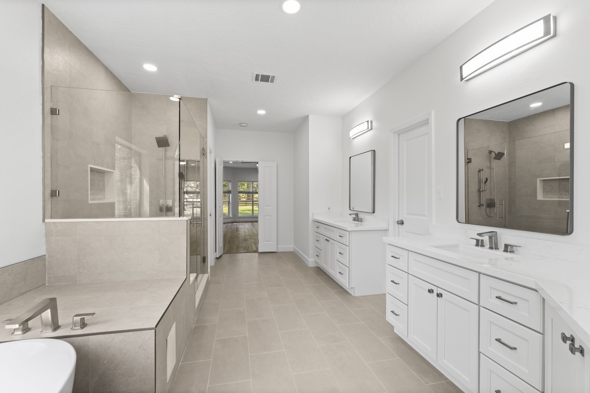 15456 Pin Oak Drive Conroe, TX 77384 - Photo 27 of 44 a large bathroom with a double vanity sink a large mirror and shower