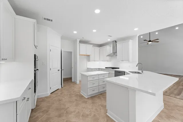 a kitchen with a sink a stove a refrigerator and white cabinets
