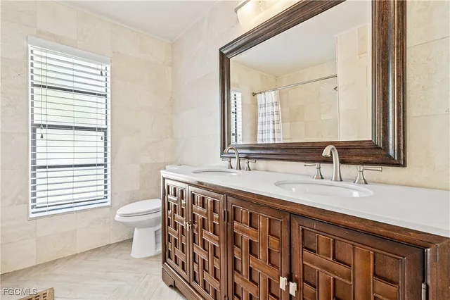 a bathroom with a granite countertop sink a toilet and a mirror
