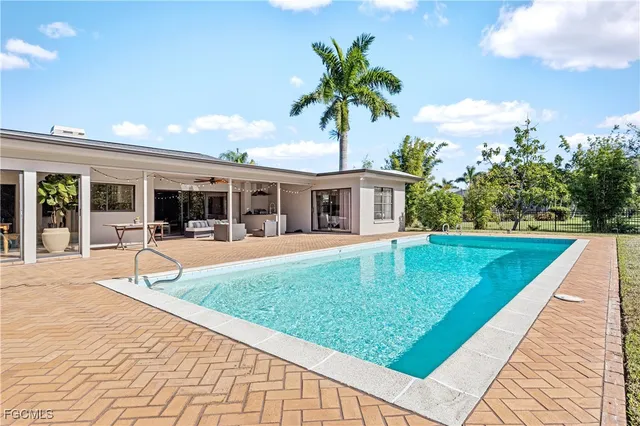 a swimming pool with outdoor seating and yard