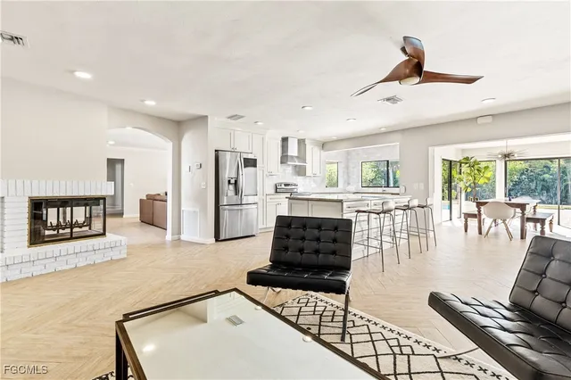 a living room with furniture and a open kitchen view