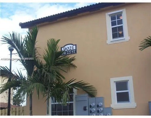 a couple of palm trees in front of a house