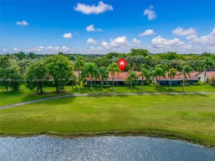 a front view of a house with a garden and trees