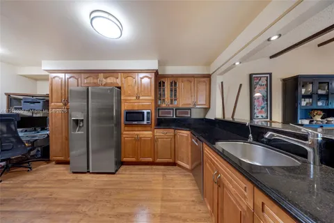 a kitchen with granite countertop a refrigerator and a sink