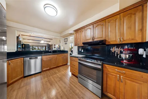 a kitchen with granite countertop wooden cabinets and stainless steel appliances