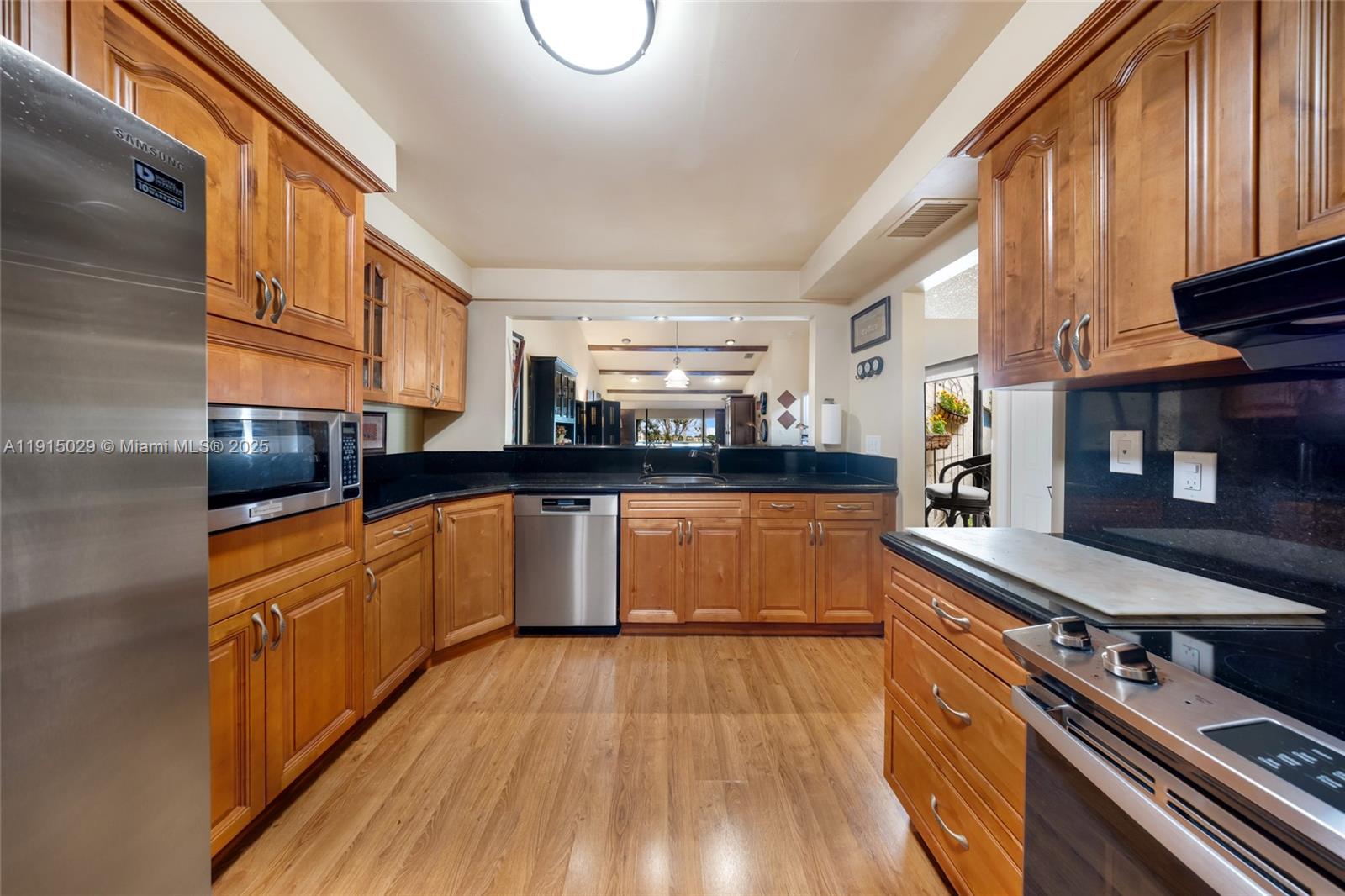 16175 Laurel Drive, Unit 27 Weston, FL 33326 - Photo 9 of 22 a large kitchen with stainless steel appliances granite countertop a stove and a sink