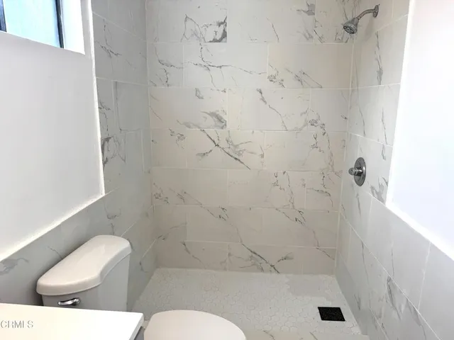 a white toilet sitting next to a bath tub