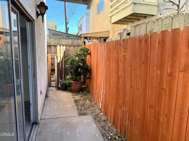 a view of a patio with table and chairs and wooden fence