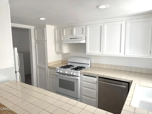 a kitchen with stainless steel appliances granite countertop a stove and a refrigerator