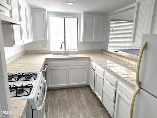 a kitchen with a sink stove and cabinets