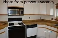 a kitchen with a sink a stove and cabinets