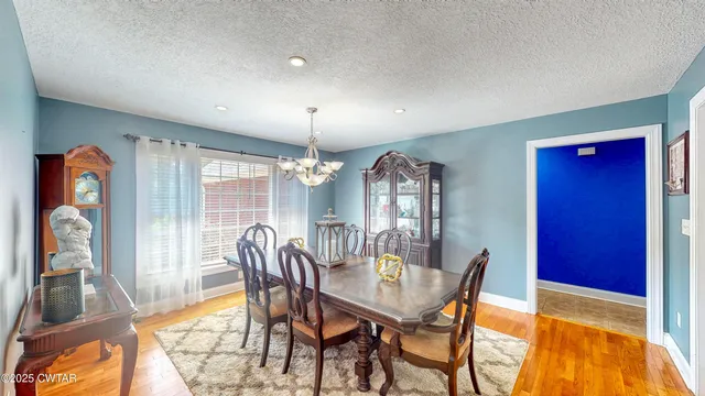 a dining room with furniture a chandelier and wooden floor