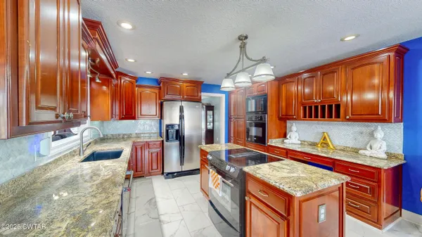 a view of a dining room with furniture a kitchen and chandelier