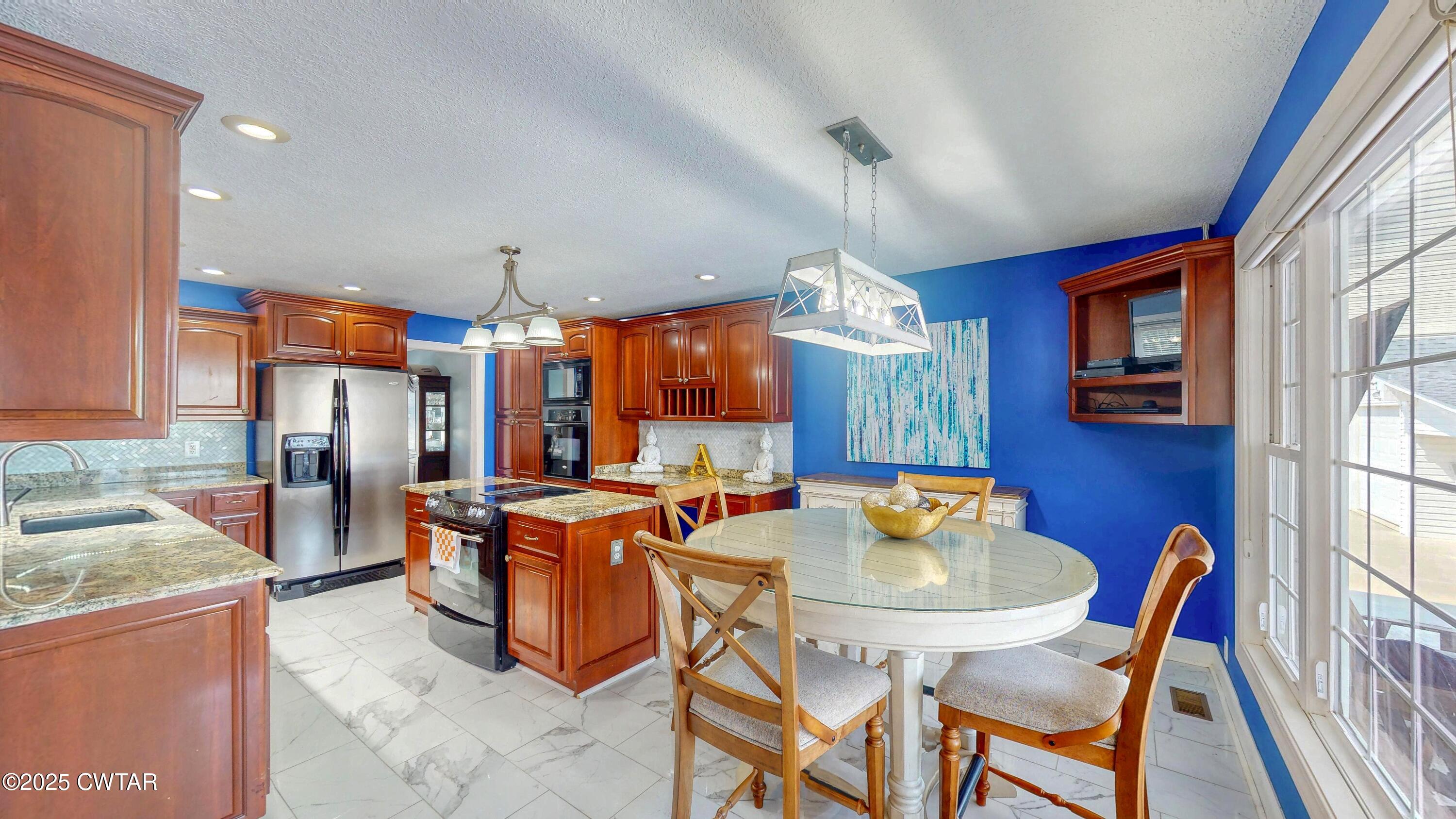 2345 East Grove Road Gleason, TN 38229 - Photo 9 of 44 a view of a dining room with furniture a kitchen and chandelier