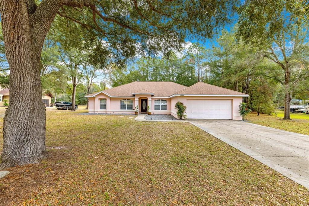 21595 Southwest 84th Loop Dunnellon, FL 34431 - Photo 45 of 62 a front view of a house with a yard and large trees