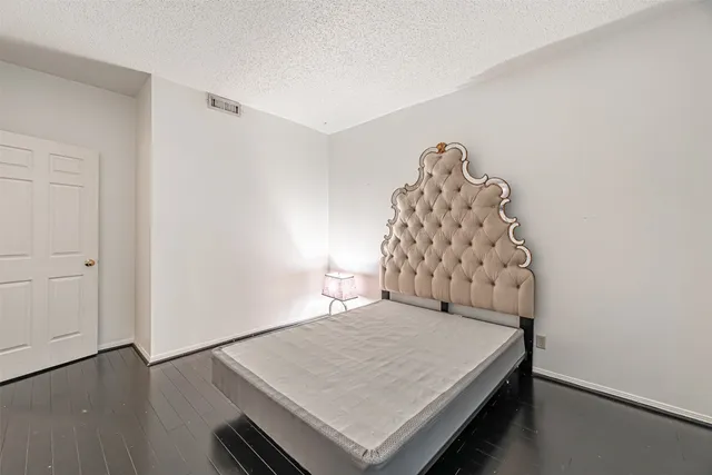 a room with a bed and a wooden floor