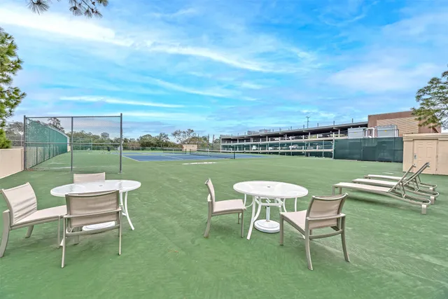 a chairs and table in swimming pool next to a yard
