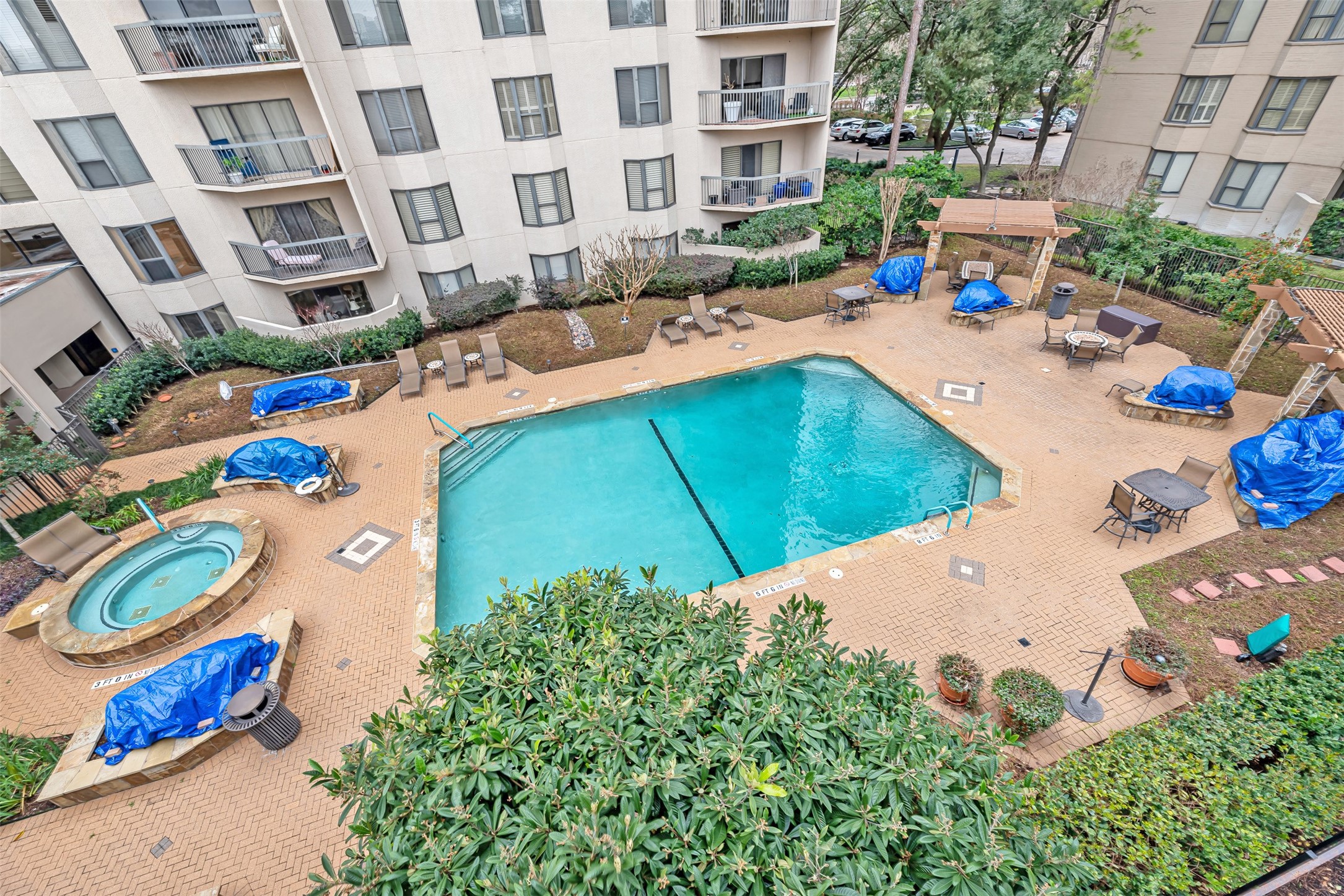661 Bering Drive, Unit 404 Houston, TX 77057 - Photo 22 of 28 a view of a swimming pool with a lounge chairs in front of a house