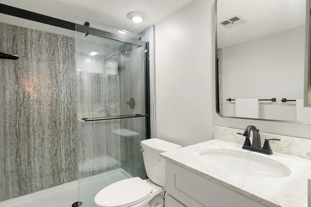 a bathroom with a sink toilet and shower