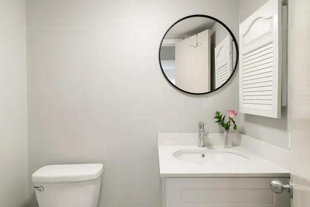 a bathroom with a sink a toilet and a mirror
