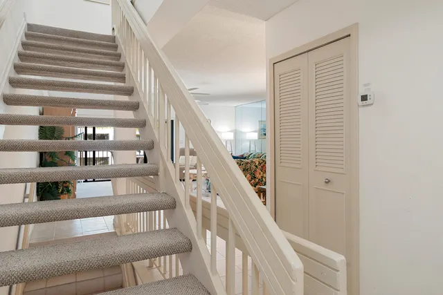 a view of staircase with lots of frames on wall and a window