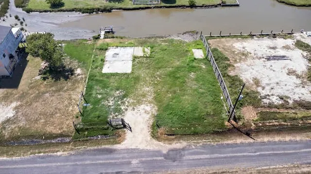 an aerial view of a house with a yard and lake view