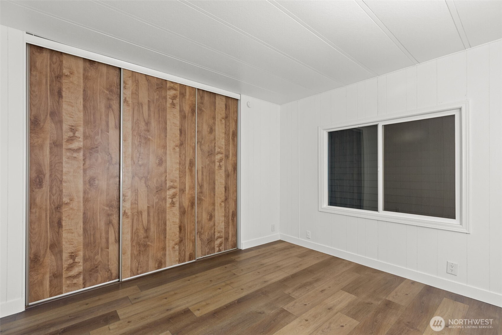11436 Southeast 208th Street, Unit 7 Kent, WA 98031 - Photo 14 of 21 a view of an empty room with wooden floor and a window