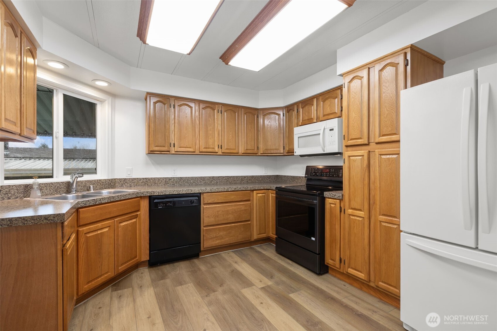 11436 Southeast 208th Street, Unit 7 Kent, WA 98031 - Photo 2 of 21 a kitchen with granite countertop stainless steel appliances and wooden cabinets