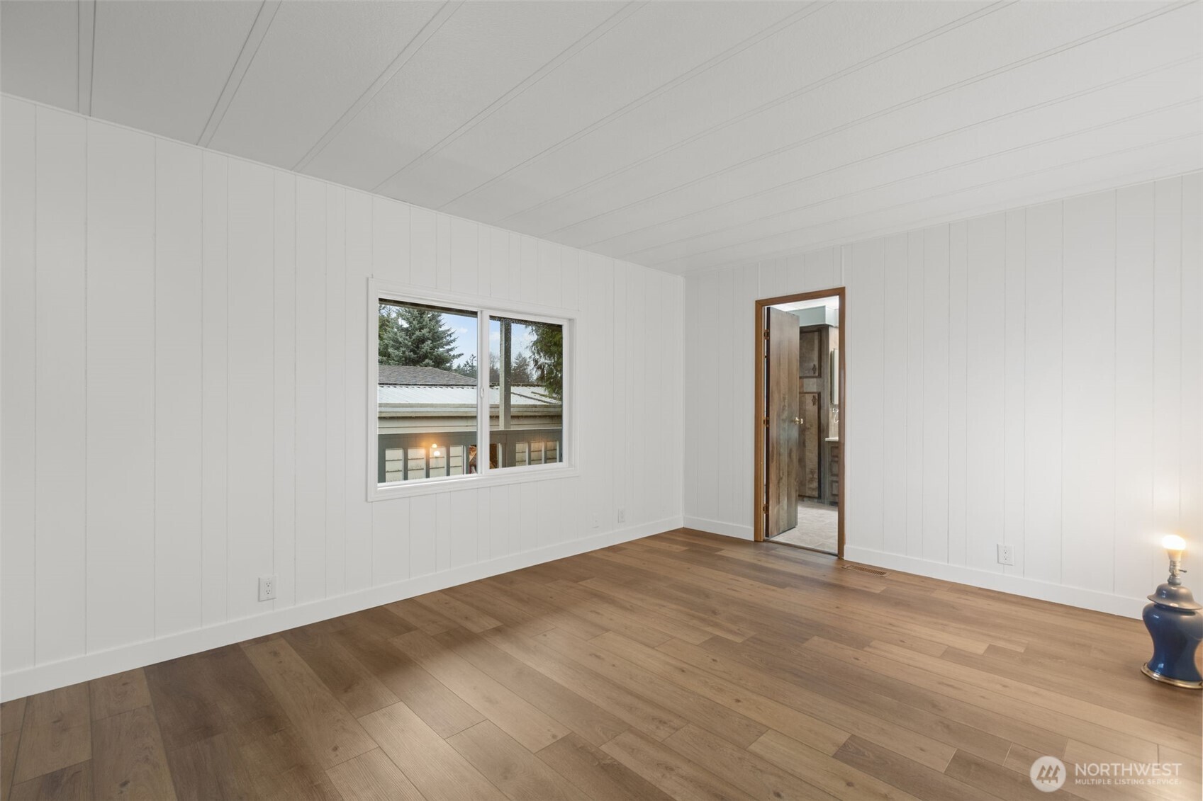 11436 Southeast 208th Street, Unit 7 Kent, WA 98031 - Photo 9 of 21 a view of an empty room with wooden floor and a window