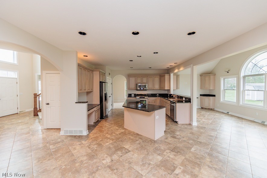 6947 Som Center Road Solon, OH 44139 - Photo 26 of 50 Kitchen featuring appliances with stainless steel finishes, sink, light tile floors, and a kitchen island