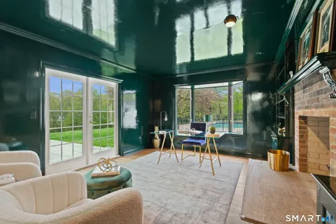 a view of a patio with couches dining table and chairs with wooden floor and fence