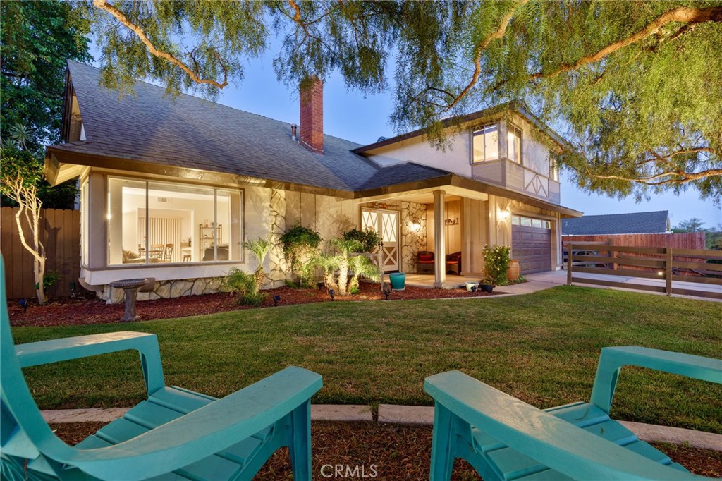 a view of a house with backyard and sitting area